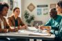 Diverse group of changemakers meeting at a community center table, sharing notes and collaborating as one person organizes documents for a hiring role, with no readable text.